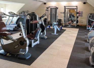 Fitness gym featuring various exercise machines and equipment, part of the luxury amenities available at Woodland Lakes Holiday Lodges, promoting health and wellness for guests.