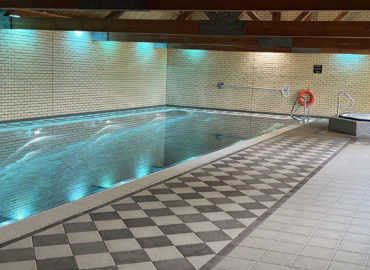 Indoor swimming pool at Oaks 5* Health Spa, featuring tiled flooring, serene lighting, and a relaxing atmosphere, ideal for couples staying at Rowan Boutique Lodge.