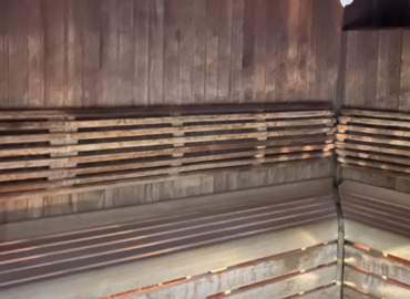 Interior view of a wooden lodge featuring rustic timber walls and illuminated slats, reflecting the luxury and comfort of the Rowan Boutique Lodge at Woodland Lakes Holiday Lodges.