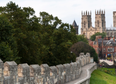 York city wall with trees and York Minster in the background, showcasing the historic architecture and scenic views near Woodland Lakes Holiday Lodges.