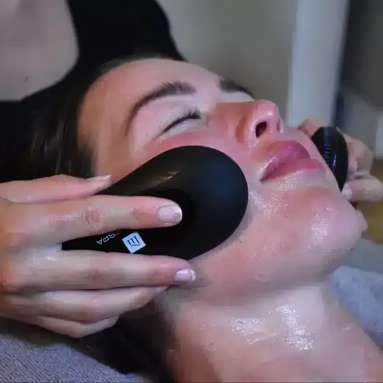 Person receiving a facial treatment in a tranquil spa environment emphasizing wellness